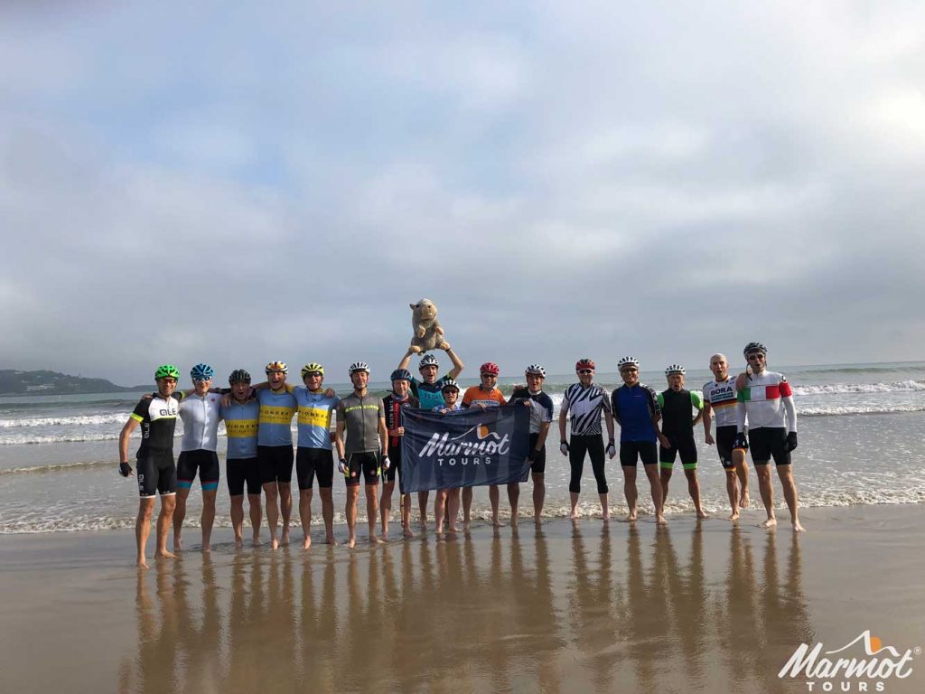 Group of cyclist in sea at start of Raid Pyrenean cycling challenge Marmot Tours