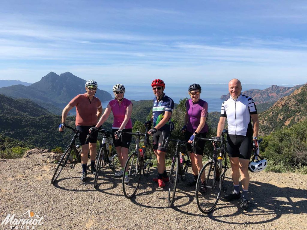 Group of cyclists overlooking coast on supported group cycling holiday in Corsica with Marmot Tours