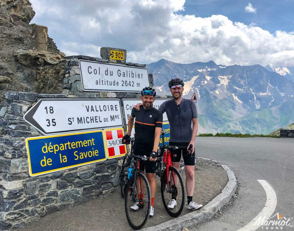 Two cyclists smiling on the Col du Galibier with Marmot Tours road cycling holidays in the Alps