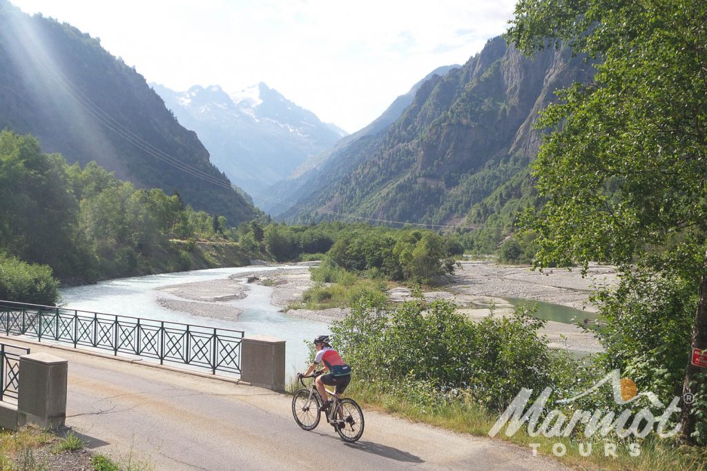Cyclist crossing bridge in the Alps on Marmot Tours Tour de France road cycling holiday