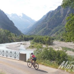 Cyclist crossing bridge in the Alps on Marmot Tours Tour de France road cycling holiday