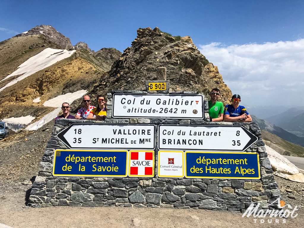 Cyclists at summit of Col du Galibier cycling climb with Marmot Tours road cycling holiday in Alps