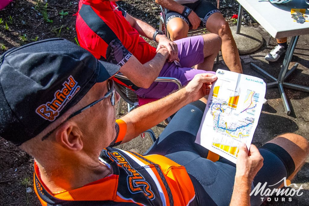 Cyclist reading Marmot Tours supported road cycling holiday trip notes