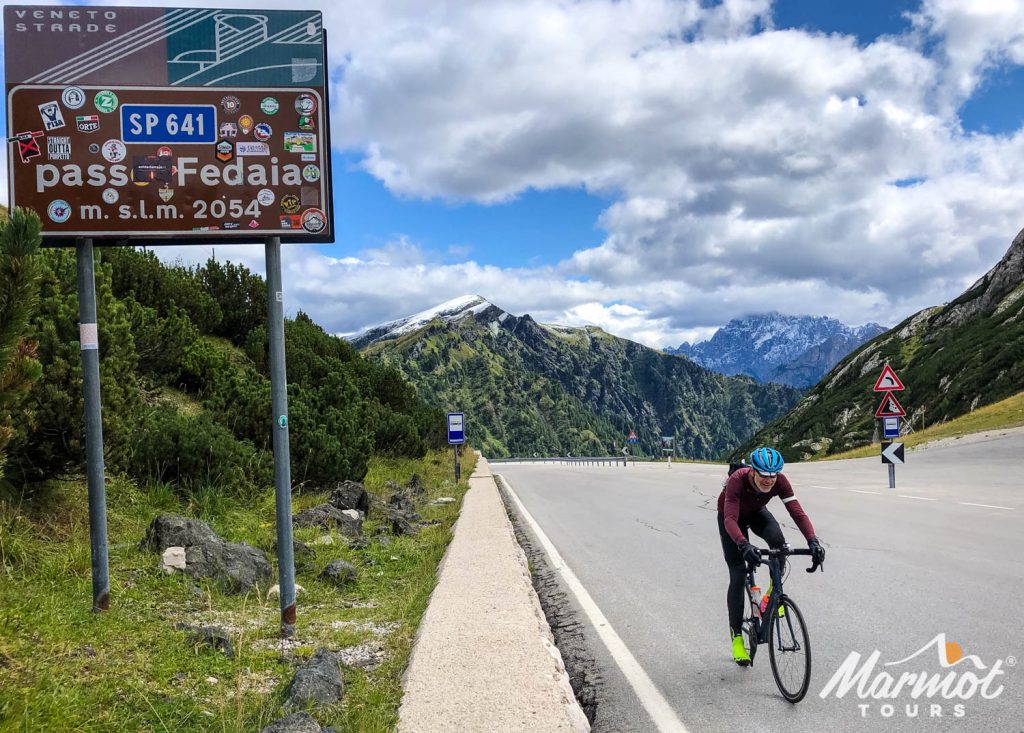 Cyclist climbing Passo Fedaia on Italian Dolomites fully supported road cycling holiday with Marmot Tours