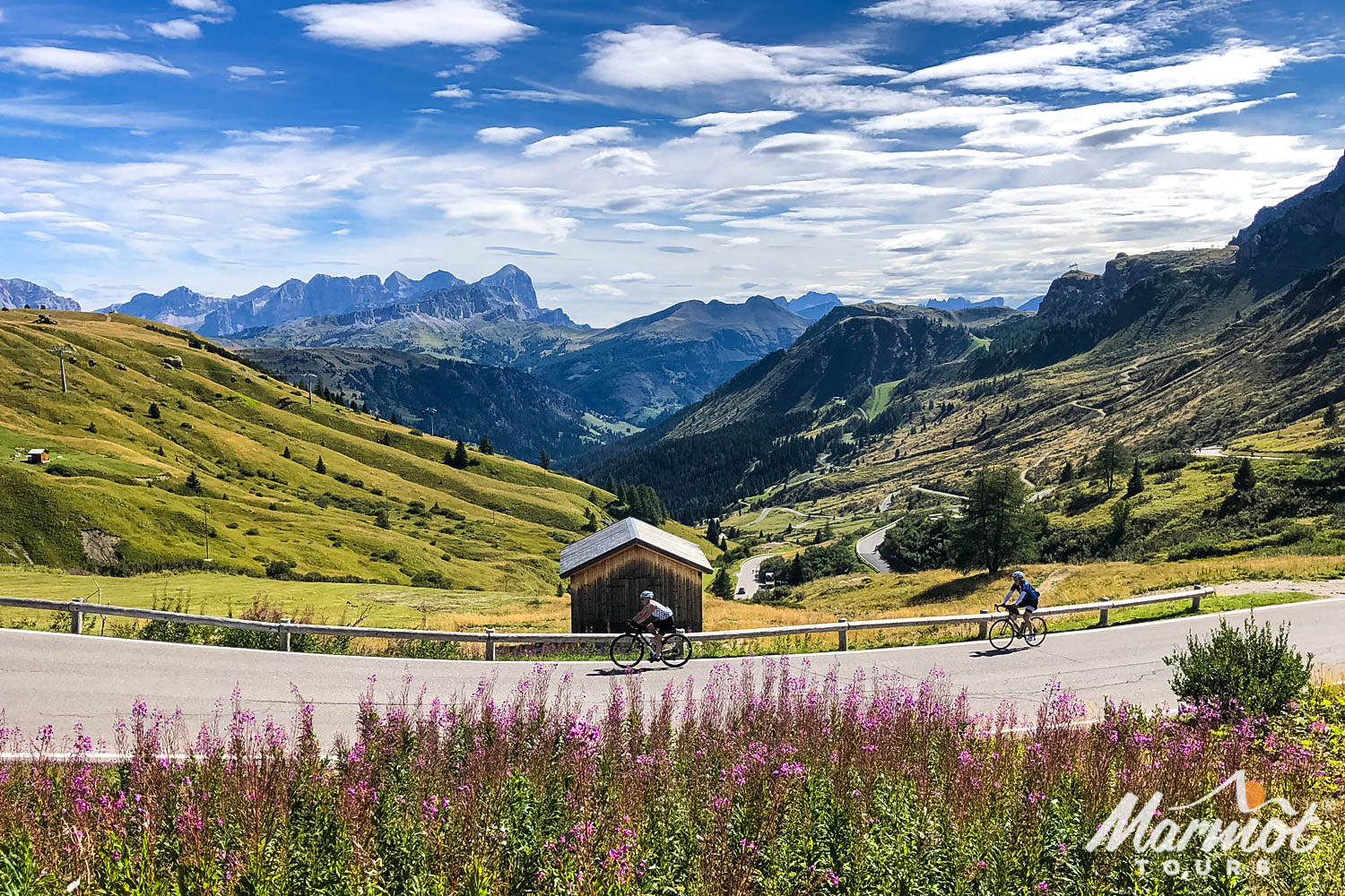 Pair of cyclists with beautiful landscape of Dolomites Italy on Marmot Tours road cycling holiday