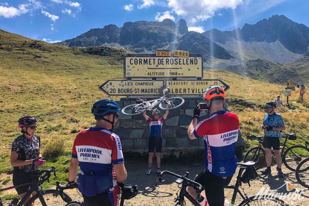 Group of cyclists celebrating on Cormet de Roselend on road cycling holiday French Alps with Marmot Tours