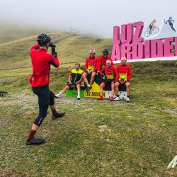 Group of cyclist posing for picture at Luz Ardiden sign on Marmot Tour full support cycling holiday in Pyrenees