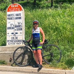 Female cyclist smiling at Col de Peyresourde on Raid Pyrenean cycling challenge with Marmot Tours