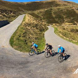 Three cyclists climbing hairpin bend on French Pyrenees road cycling holiday with Marmot Tours