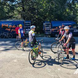 Group of cyclists and Marmot Tours support vans on guided road cycling tour of French Pyrenees