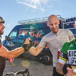 Cyclists congratulating one another at summit of Mont Ventoux with Marmot Tours support