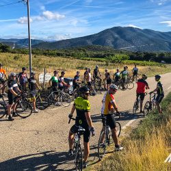 Group of cyclists pausing for a rest on road at bases of Mont Ventoux on Marmot Tours guided road cycling tour Provence France