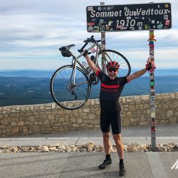 Cyclist listing up bike and celebrating 3rd ascent of Mont Ventoux on Marmot Tours guided cycling tour