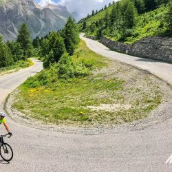 Cyclist thumbs up rounding a hairpin bend on Col de l'Iseran on Marmot Tours guided cycling tour of French Alps