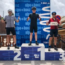 Three cyclists celebrate on the Alpe d'Huez podium on Marmot Tours guided cycling tour of French Alps