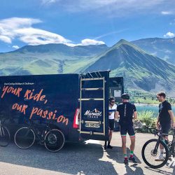 Group of cyclists enjoy snacks and water from support van on Marmot Tours guided cycling tour of French Alps