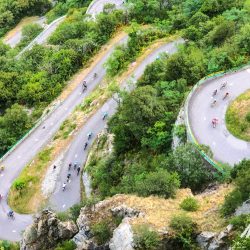 Aerial image of cyclist climbing multiple switchbacks on Lacets du Montvernier on Marmot Tours guided cycling tour of French Alps