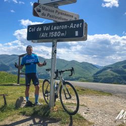 Cyclist with thumbs up at Col de Val Louron-Azet on fully supported road cycling holiday in France Pyrenees with Marmot Tours