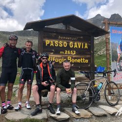 Cyclists smiling at Passo Gavia sign on Marmot Tours guided cycling tour of Dolomites Italy