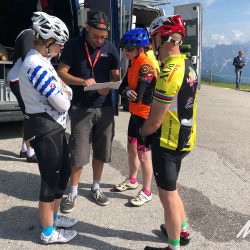 Marmot Tours guide showing group of cyclists a map on guided road cycling holiday of Dolomites Italy