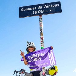 Female cyclist at summit of Mont Ventoux charity bike ride with Marmot Tours