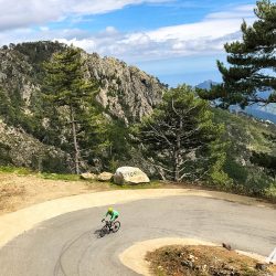 Cyclist on hairpin bend in beautiful countryside on Marmot Tours guided cycling holiday in Corsica