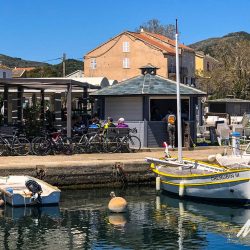 Cyclists in harbourside cafe on Marmot Tours guided road cycling holiday in Corsica