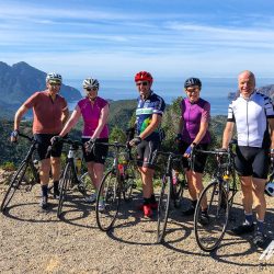 Group of cyclists with coastal backdrop on Marmot Tours