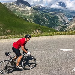 Cyclist putting in the effort on a big climbon Marmot Tours Raid Alpine cycling challenge French Alps