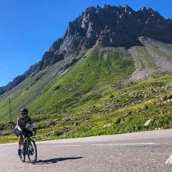 Female cyclist climbingon Marmot Tours Raid Alpine cycling challenge French Alps