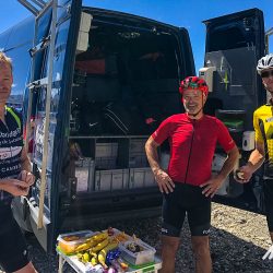 Cyclists enjoying snack break at Marmot Tours support vehicleon Marmot Tours Raid Alpine cycling challenge French Alps