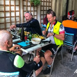 Cyclists enjoying lunch in courtyard restaurant on Marmot Tours Raid Massif Central French cycling holidays