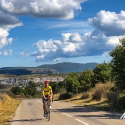 Cyclist enjoying climb in sunshine on Marmot Tours Raid Massif Central French cycling holidays