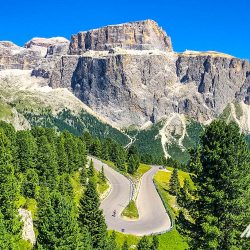 Cyclist on hairpin bend with mountainous backdrop on Marmot Tours guided road cycling tour Dolomites Italy