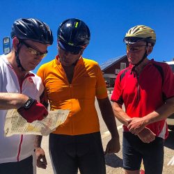 Trio of cyclists looking at route notes on Marmot Tours guided road cycling tour Dolomites Italy