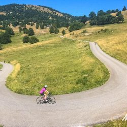 Cyclists enjoying Alpine hairpin bends on supported road cycling short break in French Alps with Marmot Tours