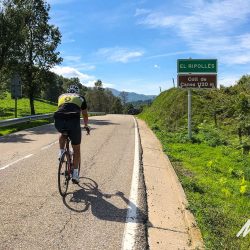 Cyclist climbing Coll de Canes in sunshine on Marmot Tours guided cycling tour Girona Catalonia Spain with full support
