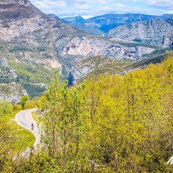 Cyclist on winding road through deep gorge on Marmot Tours guided road cycling tour Mont Ventoux Provence France
