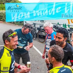 Marmot Tours guide pours champagne for finishing cyclists of Raid Corsica