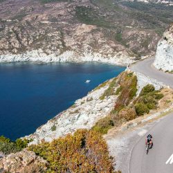 Cyclist on beautiful coast road above sea on west coast of Corsica on Marmot Tours full support Raid Corsica cycling holiday