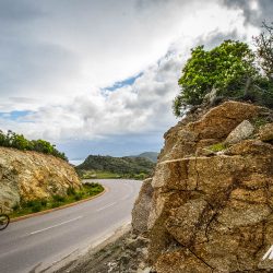 Cyclist enjoying rocky climb on Raid Corsica with marmot Tours guided road cycling holidays