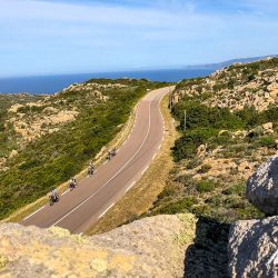 Group of cyclists enjoying coast road ride in sunshine on Raid Corsica with Marmot Tours road cycling holidays