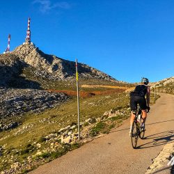 Female cyclist nearing summit of Gamoniteiro in Picos de Europa Northern Spain guided road cycling tour with Marmot Tours