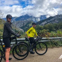 Two female cyclists resting with mountainous backdrop in Picos de Europa Northern Spain with marmot Tours road cycling holidays and challenges
