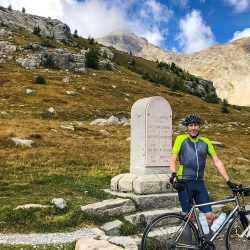 Cyclist and bike pausing at Col de la Cayolle in Southern Alps on Marmot Tours fully supported road cycling holiday