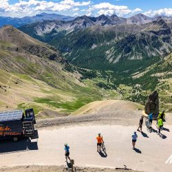 Group of cyclists and Marmot Tours support vehicle with mountain views in Southern Alps