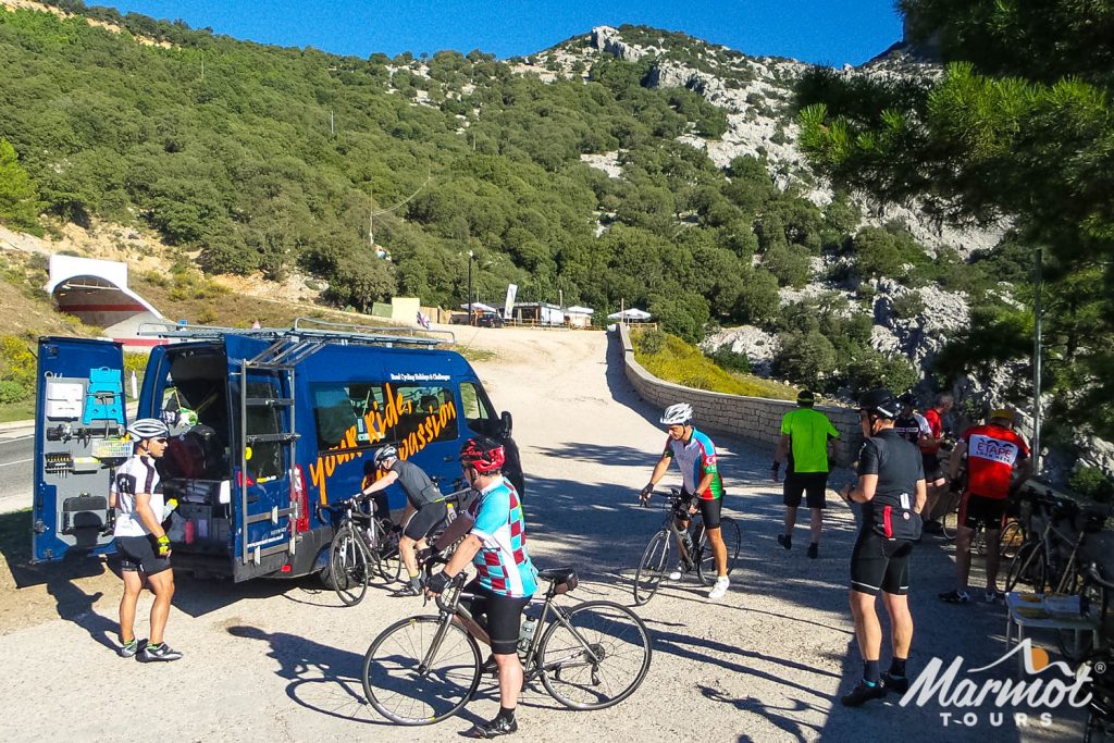 Group of cyclists enjoying rest and snacks at support vehicle on Marmot Tours guided road cycling holiday