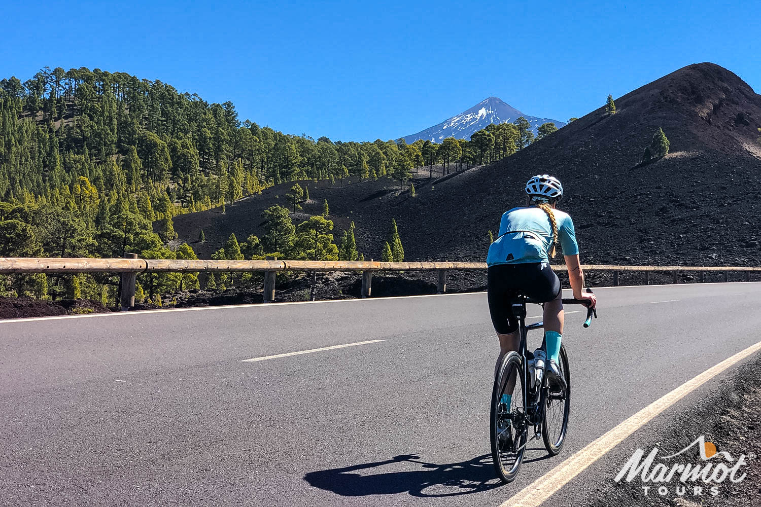 Female cyclist enjoying smooth road in Tenerife with Mount Teide backdrop on Marmot Tours guided road cycling holiday Tenerife