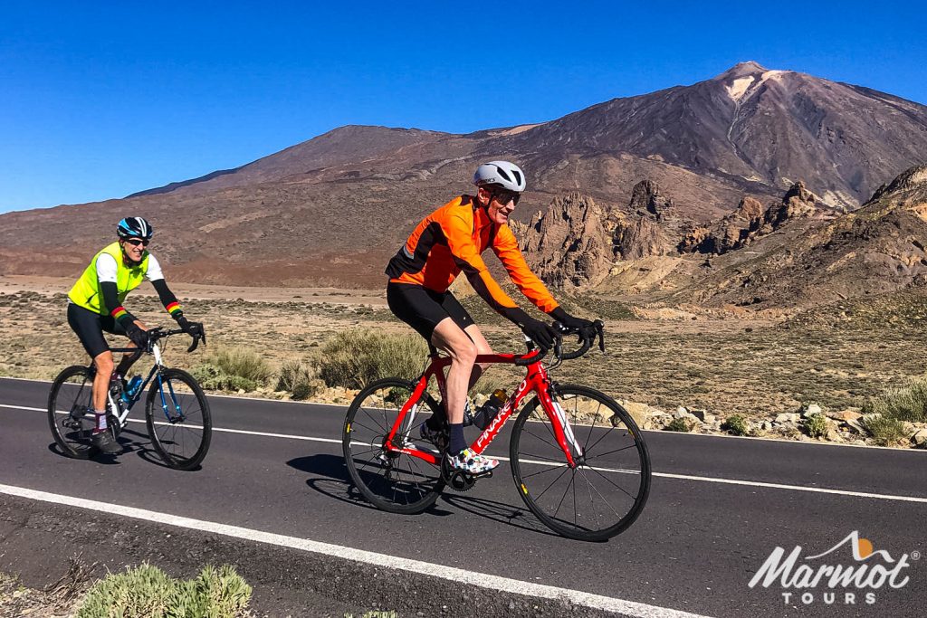 Pair of cyclists enjoying winter sun cycling in Tenerife with Mount Teide