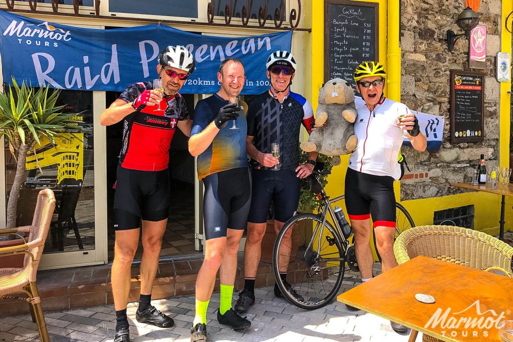 Cyclists celebrating finish of Raid Pyrenean with champagne and Marmot Tours